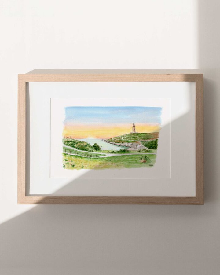 Ilustración en acuarela de A Coruña al atardecer con la Torre de Hércules bajo un cielo dorado y anaranjado enmarcada en madera