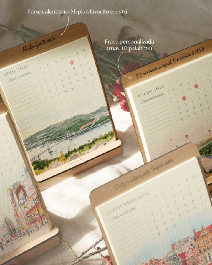 Detalle de calendario ilustrado 2026 con frases personalizables y páginas de acuarela artesanal sobre soporte de madera