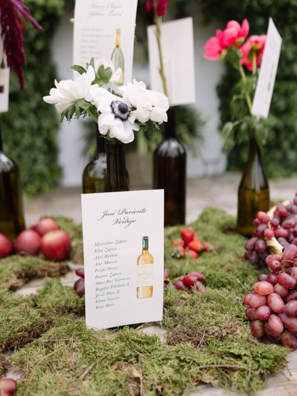 Conjunto de papelería de boda artesanal con ilustraciones en acuarela a mano expuesto sobre mesa con decoración natural y rústica