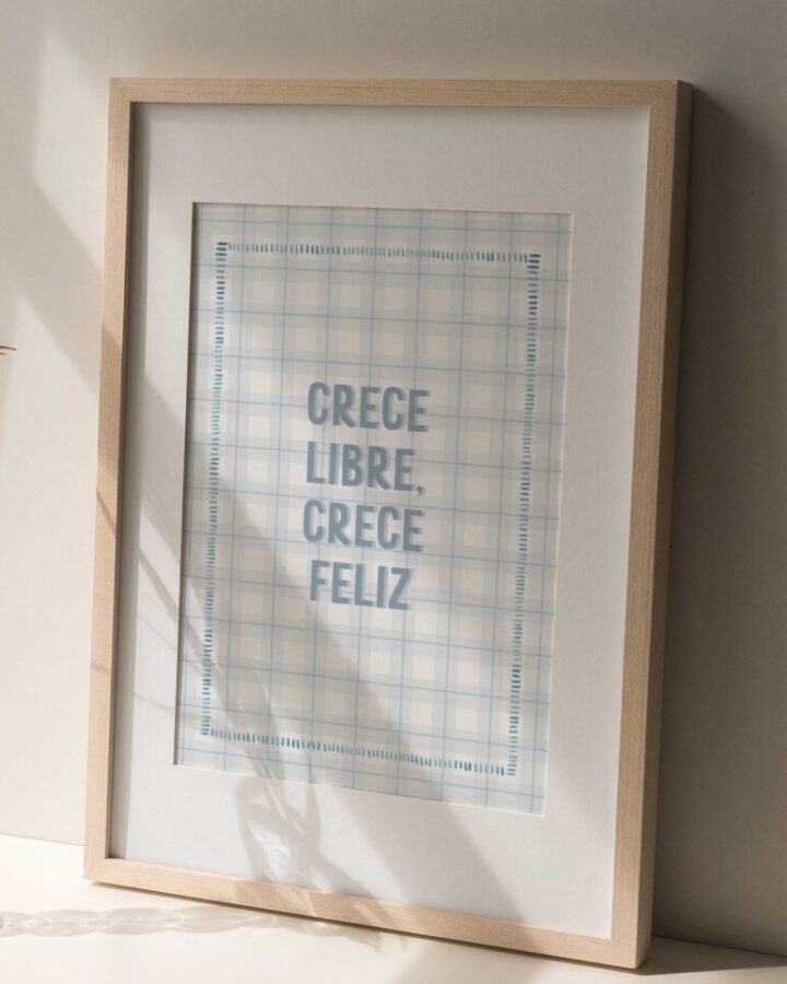 Lámina enmarcada con la frase Crece Libre Crece Feliz sobre fondo de estampado vichy azul celeste en marco de madera natural