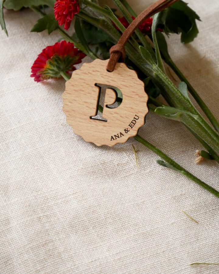 Llavero artesanal de madera con inicial decorativa grande cortada y nombres de los novios grabados de la colección Ondas