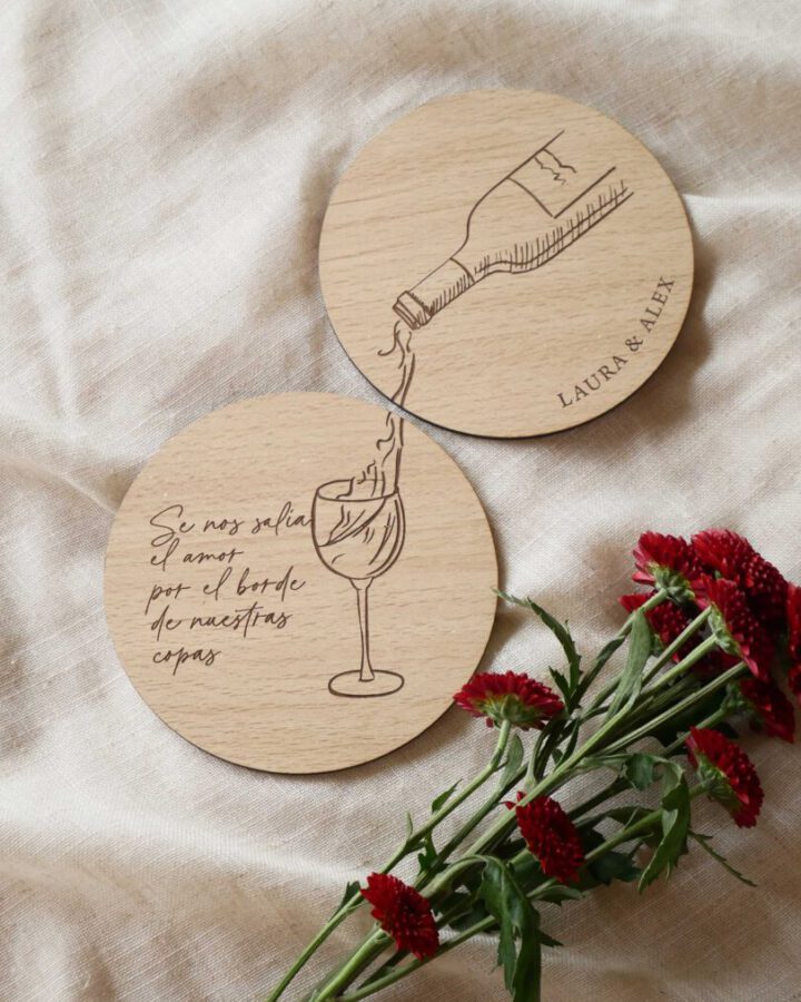 Dos posavasos artesanales de madera con grabado láser de copa de vino, nombres de pareja y frase personalizada para detalle de boda