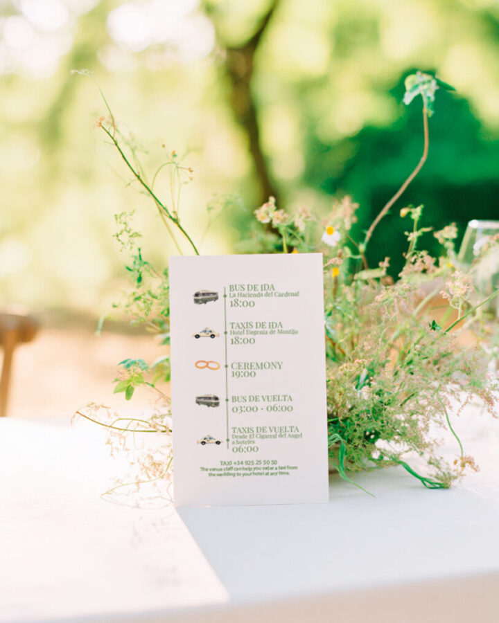 Tarjeta de horarios de transporte para invitados de boda con iconos ilustrados de autobús, taxi y ceremonia sobre fondo de flores silvestres