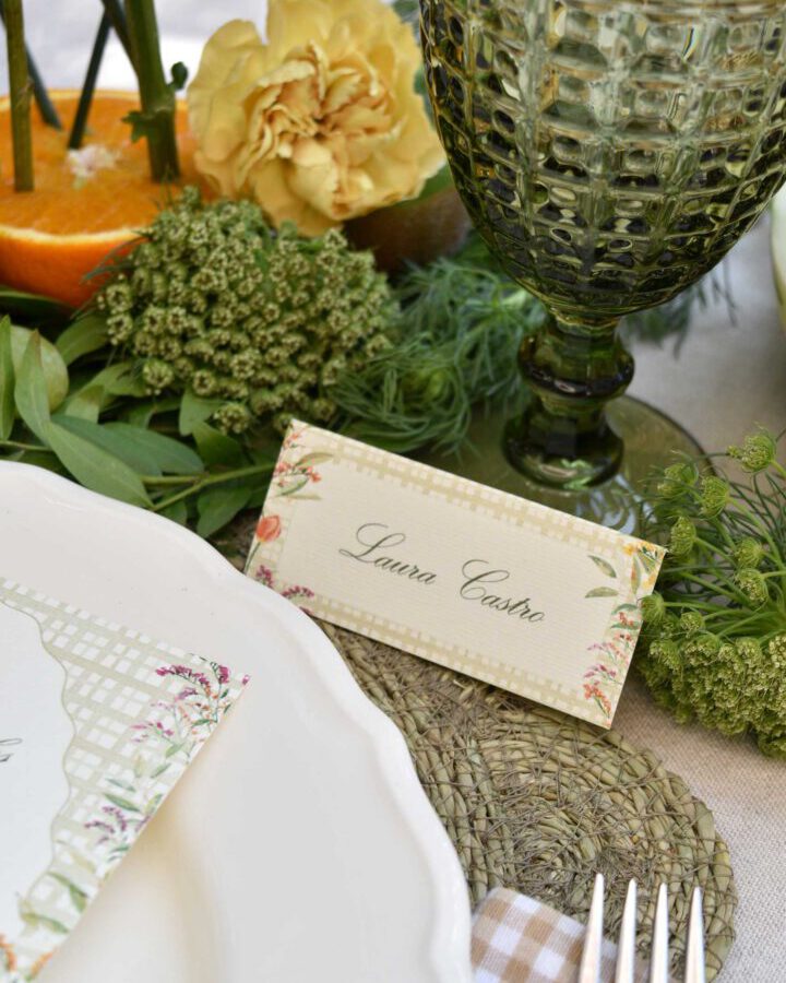 Marcasitio díptico con flores de otoño en acuarela y nombre caligráfico sobre mesa decorada con mantelería verde y calabaza