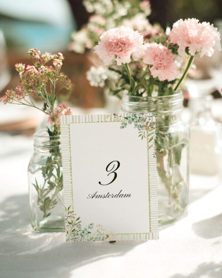 Mesero de boda campestre con número tres y nombre de mesa en caligrafía decorado con ilustraciones de flores silvestres en acuarela