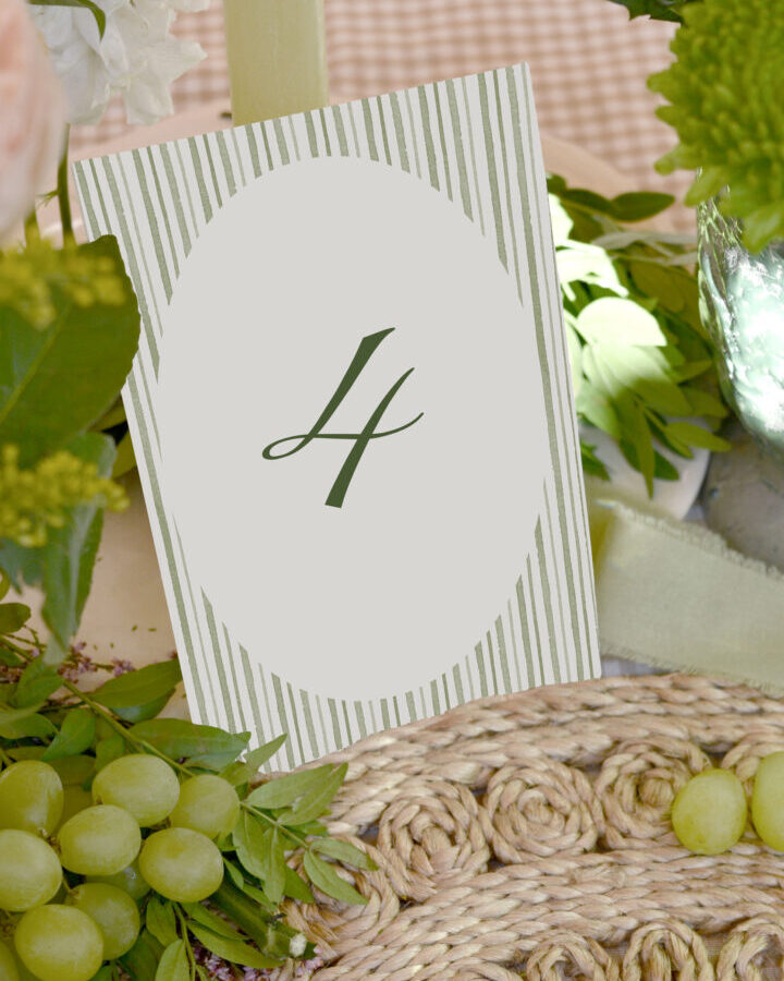 Mesero de boda número cuatro con diseño a rayas verdes y tipografía caligráfica elegante sobre salvamanteles de fibra natural