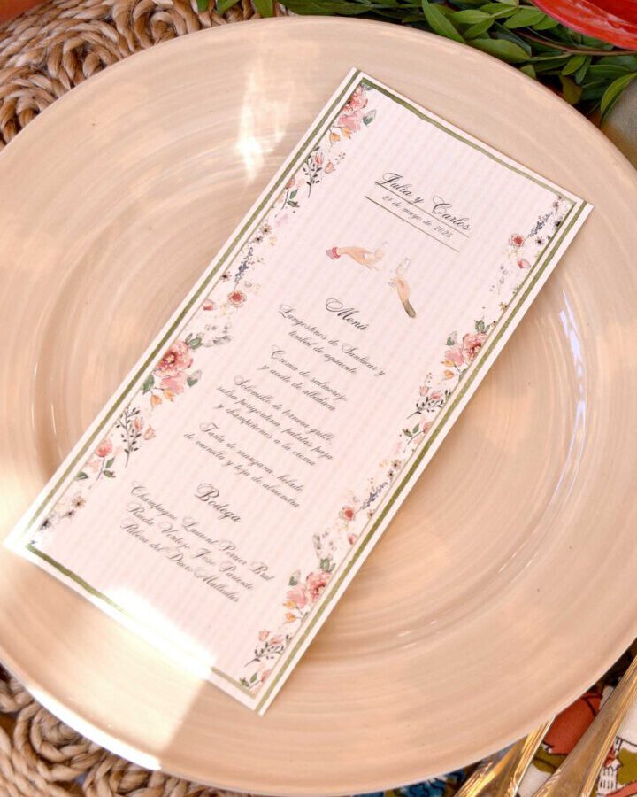 Minuta de boda con diseño de rosas y flores delicadas pintadas a mano en acuarela presentada sobre plato elegante